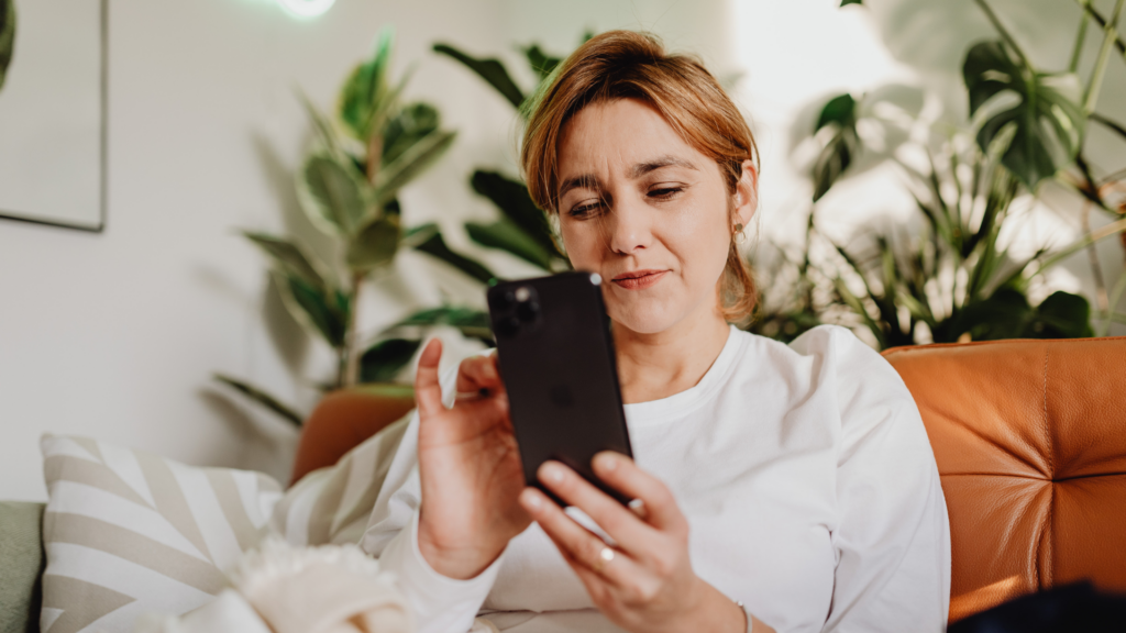 Woontrends van 2025_Vrouw met telefoon in zetel